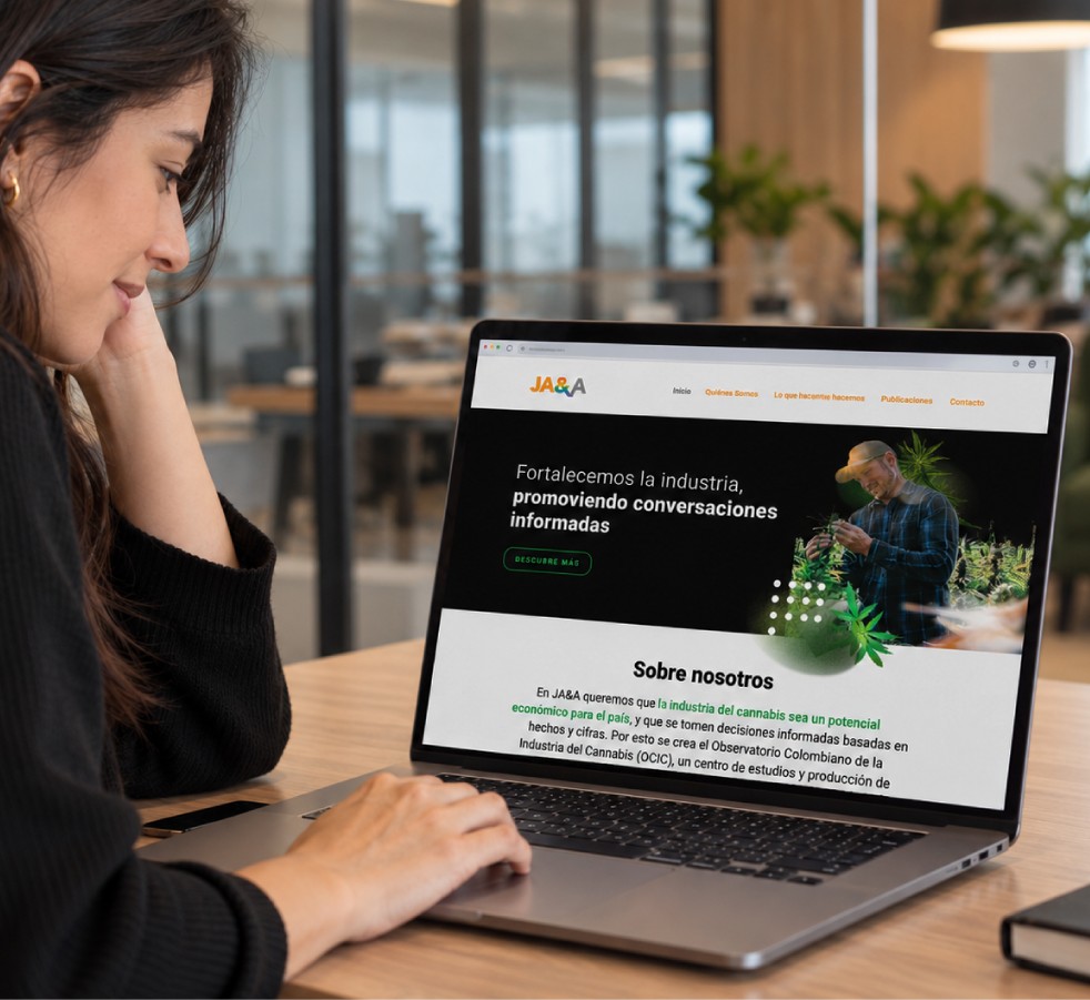 Una persona frente a un portátil que muestra el sitio web de JA&A, con el lema «Fortalecemos la industria, promoviendo conversaciones informadas» y la sección «Sobre nosotros».